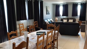 Un coin repas avec une table dressée pour quatre personnes, entourée de chaises en bois.