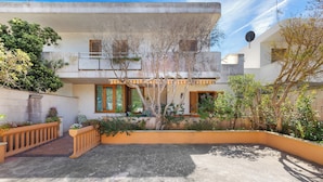A modern two-story house with a courtyard, featuring a balcony, a satellite dish, and a variety of plants. - 3897 Villa Margarita by Barbarhouse (Lecce)
