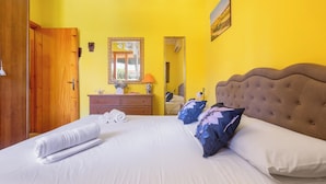 A neatly made bed with white linens and a brown headboard, a wooden wardrobe, a dresser with a mirror, and a painting on the wall. - 3897 Villa Margarita by Barbarhouse (Lecce)