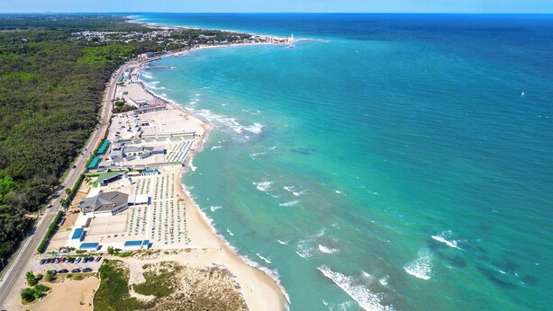 An aerial view of a coastal area with a beach, a road, and a row of buildings with a parking lot. - 3897 Villa Margarita by Barbarhouse (Lecce)