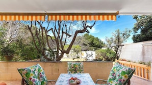 An outdoor patio with a table set for two, surrounded by wicker chairs with cactus-patterned cushions, under a striped awning. - 3897 Villa Margarita by Barbarhouse (Lecce)