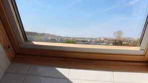 A skylight with a view of a marina and buildings. - Chudzik Modern Retreat (Rerik)