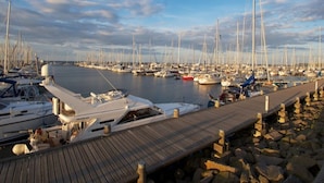A marina with numerous sailboats docked, wooden walkways, and calm water. - Chudzik Modern Retreat (Rerik)