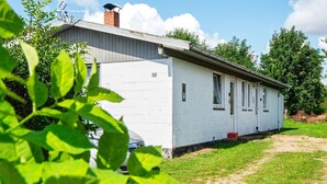 A single-story building with a white exterior, a visible chimney, and a small front porch. - 3 Person Holiday Home in Sydals (Sydals)