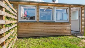 A wooden cabin with three windows, a door, and a small porch area. - 3 Person Holiday Home in Sydals (Sydals)