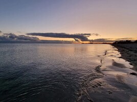 A beach with calm water and a clear sky.