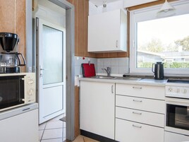 A compact kitchen with a microwave, stove, and sink.
