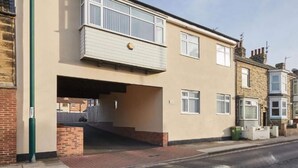 A two-story residential building with a flat roof, a balcony on the upper floor, and a covered entrance. - Jackson Court Apartment 3 (Redcar)