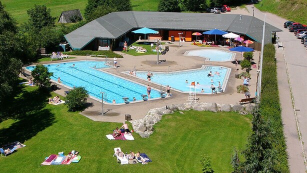 An outdoor swimming pool area with multiple pools, sun loungers, and umbrellas. - Todtmoos Modern Retreat (Todtmoos)