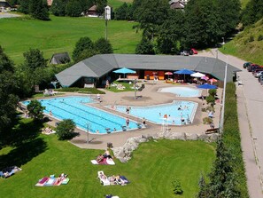 An outdoor swimming pool area with multiple pools, sun loungers, and umbrellas. - Todtmoos Modern Retreat (Todtmoos)