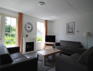 A living room with a fireplace, a television, and a sofa.