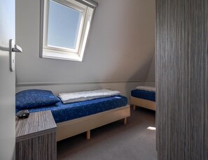 A small, single-room accommodation with a sloped ceiling, a window, and a door. - Villa Near the Lake in Makkum (Makkum)