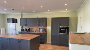 A modern kitchen with grey cabinets, a central island, and built-in appliances. - Nice Apartment in Klein Upahl (Klein Upahl)