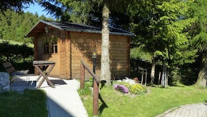 A wooden cabin with a porch and a small garden. - Holiday Apartment Family Kreissl (Oberwiesenthal)