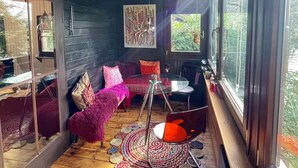Une pièce chaleureuse avec un canapé incurvé, une table en verre et un ventilateur de plafond.