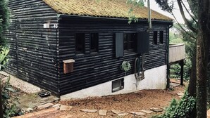 Une cabane en rondins avec un toit de chaume, portant le numéro 40, dotée d’un petit porche et d’une cheminée.