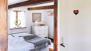 A bedroom with a bed, a dresser, a map on the wall, and a heart-shaped decoration on the door. - 6 Person Holiday Home in Degeberga (Degeberga)