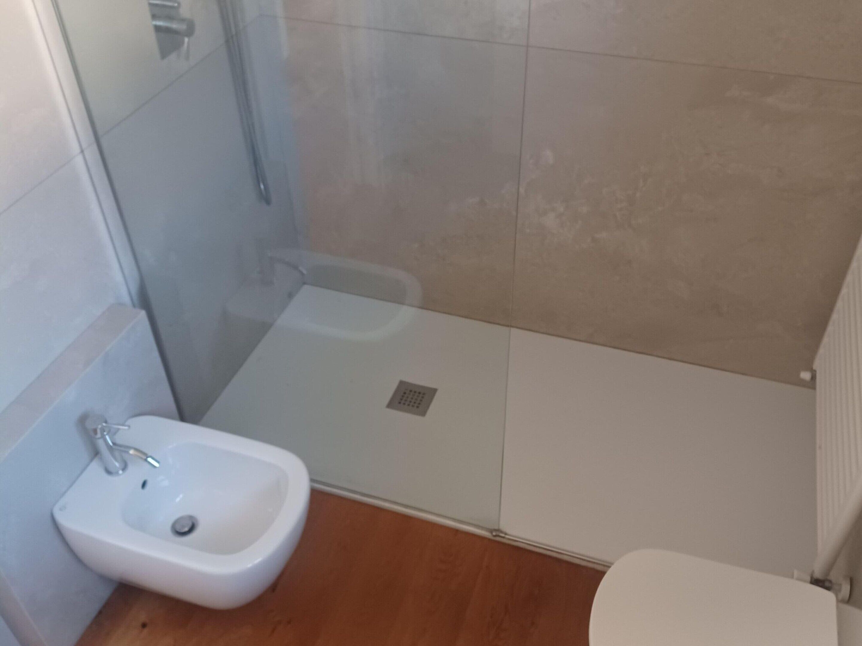 A bathroom with a shower, a sink, and a toilet.