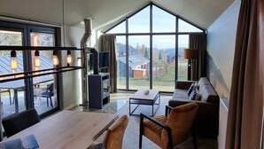 Un salon spacieux doté d’une grande fenêtre, d’une cheminée et d’un coin repas.