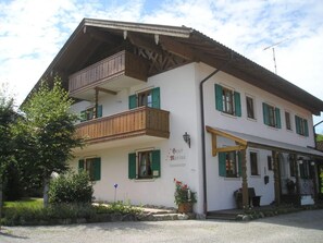A two-story building with a balcony, green shutters, and a sign that reads "Haus Marino."