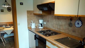 Une cuisine de taille réduite équipée d’une cuisinière, d’un four, d’un évier et d’une machine à café.