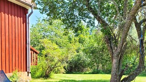A red building with a lawn and a hammock. - 5 Person Holiday Home in Gamleby (Gamleby)