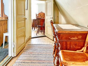 A room with a wooden desk, a chair, and a staircase. - 5 Person Holiday Home in Gamleby (Gamleby)