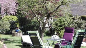 A garden with a lawn, a small table, and two chairs. - Long Comfortable Holiday Residence (Süderlügum)