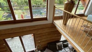 Amplio dormitorio tipo loft con un gran ventanal que da a un jardín exuberante.
