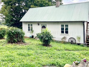 A white house with a green roof, a front door, and a small porch area. - 4 Person Holiday Home in Kopingsvik (Kopingsvik)