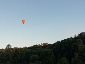 A hot air balloon in the sky above a forested hill with a building on top. - Mey Comfortable Holiday Residence (Meissen)