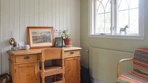 A room with a wooden desk, a chair, a radiator, and a window with a view of a statue. - 4 Star Holiday Home in Djursholm (Djursholm)