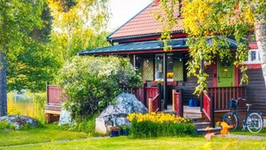 A cabin with a porch, a bicycle, and a view of a lake. - 4 Star Holiday Home in Djursholm (Djursholm)