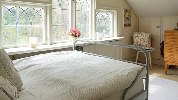 A single-bed room with a window, a radiator, a chair, and a wooden dresser. - 4 Star Holiday Home in Djursholm (Djursholm)