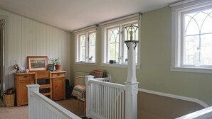 A room with a white railing, a wooden dresser, a chair, and a window with a decorative lamp post. - 4 Star Holiday Home in Djursholm (Djursholm)