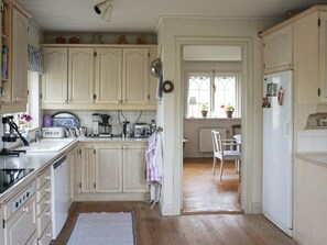 A kitchen with wooden cabinets, a coffee maker, a toaster, and a refrigerator.