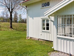A white building with a sloped roof, a small window, and a door. - 4 Star Holiday Home in Ulricehamn (Ulricehamn)