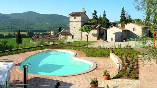 A stone building with a tower, a swimming pool, and a garden with potted plants. - Belvilla by OYO Borgo Sanvico Forrest (Corciano)