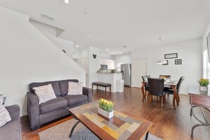 Un salon moderne avec un canapé, une table basse et un coin repas.