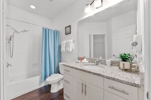 A bathroom with a bathtub, toilet, sink, and shower.
