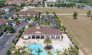 Ein Wohngebiet mit einem großen Haus, das einen Pool, eine überdachte Terrasse und eine Auffahrt hat.