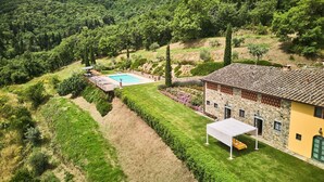 A villa with a swimming pool, stone walls, and a well-maintained garden. - Serene Chianti Retreat (Cavriglia)