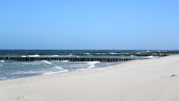 A beach with a long pier extending into the ocean. - Apartment Evening sun (Zingst)