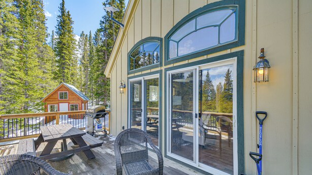 A wooden deck with outdoor furniture, a grill, and a snow shovel. - 24-0139 Cabin in Fairplay: Close to Trails! (Fairplay)