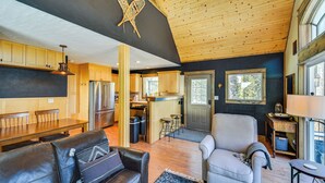 A spacious living area with a fireplace, leather sofas, and a dining table. - 24-0139 Cabin in Fairplay: Close to Trails! (Fairplay)