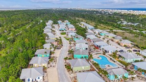 A residential area with houses, a swimming pool, and a road.