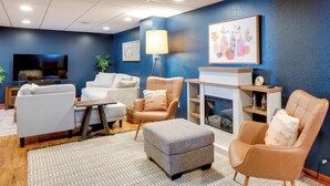 A modern living room with a blue accent wall, a flat-screen TV, and a fireplace. - Cozy Milwaukee Apartment w/ Deck, 2 Mi to Airport! (Milwaukee)