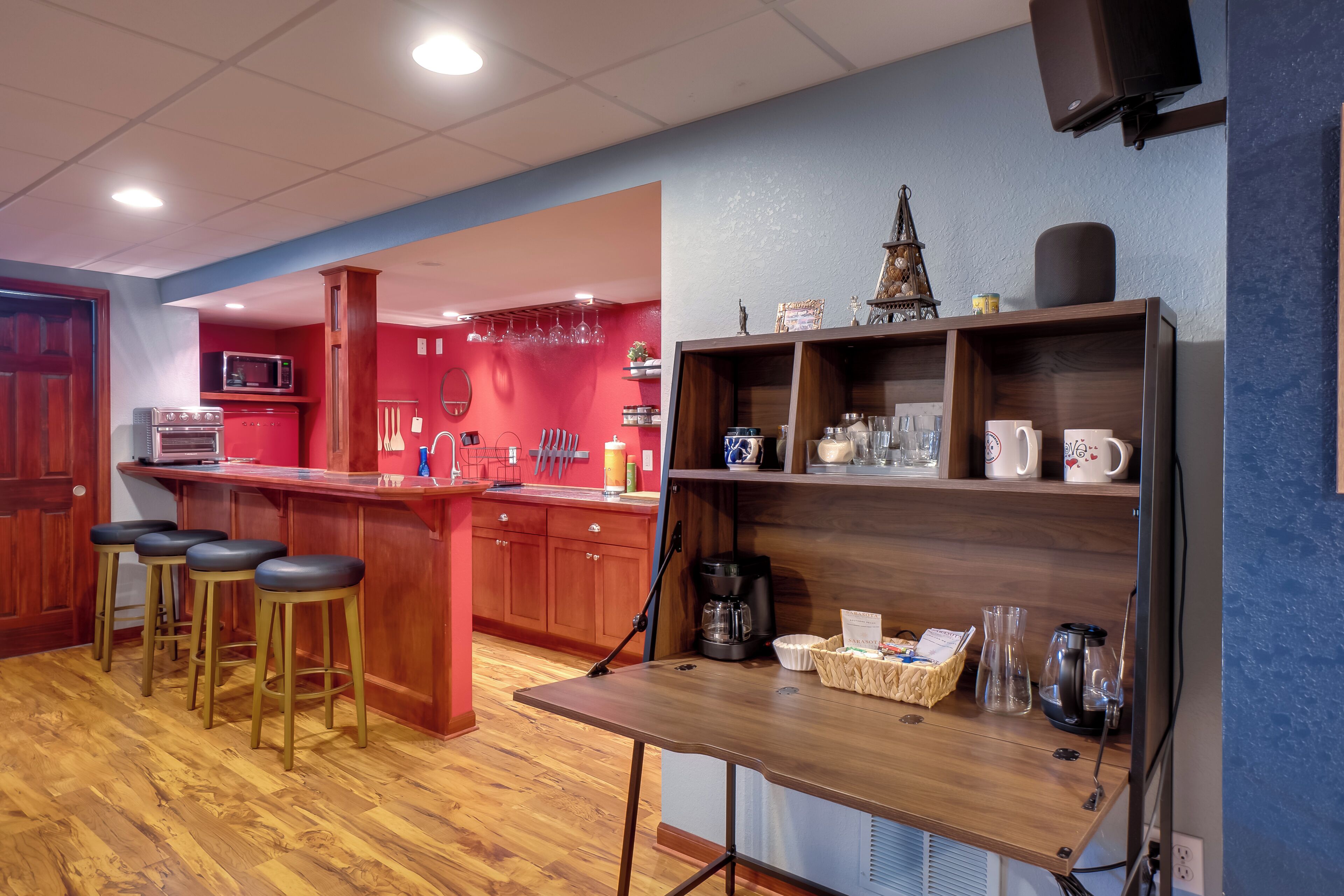 A kitchen with wooden stools, a coffee maker, and a microwave.