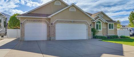 A two-story house with a garage, a driveway, and a well-maintained lawn.