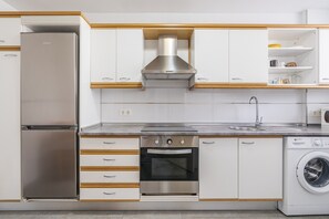 A modern kitchen with stainless steel appliances, wooden cabinetry, and a built-in oven. - Apartment 'Mediterraneo 7' with Sea View, Wi-Fi and Air Conditioning (La Herradura)